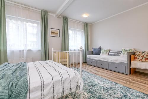 een slaapkamer met een bed en een bank bij Vienības prospekts Apartment. in Jūrmala
