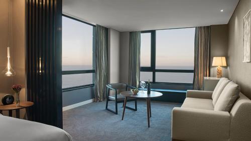 a hotel room with a bed and a couch and a table at Hyatt Centric Montevideo in Montevideo