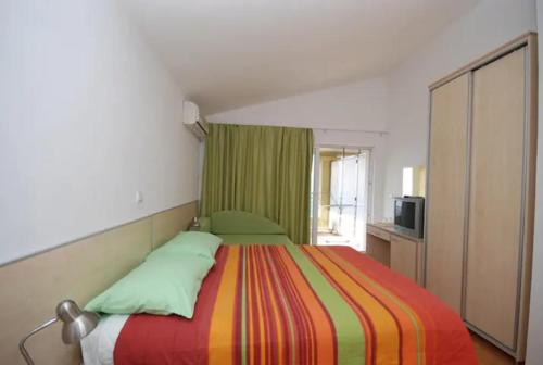 ein Schlafzimmer mit einem großen Bett mit einer bunten Decke in der Unterkunft BMV room with east island view in Sveti Stefan