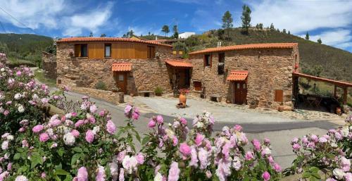 Un edificio con un mazzo di fiori davanti di REFÚGIO DO RAPOSO/CASA VEGA a Montes da Senhora
