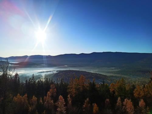 een uitzicht op de zon die schijnt over een vallei met bomen bij Szklarska Centrum in Szklarska Poręba