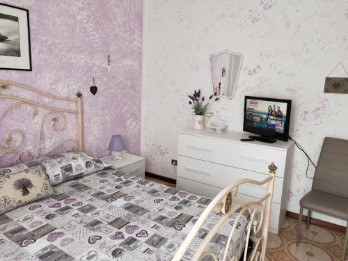 1 dormitorio con cama y vestidor con TV en Yellow Submarine Freeparking petfriendly, en Rapallo