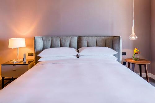 a bedroom with a large bed with white sheets and pillows at Hyatt Centric Montevideo in Montevideo