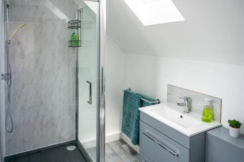 uma casa de banho com um chuveiro e um lavatório. em Walking distance to hospital and town with free off-road parking em Bury Saint Edmunds