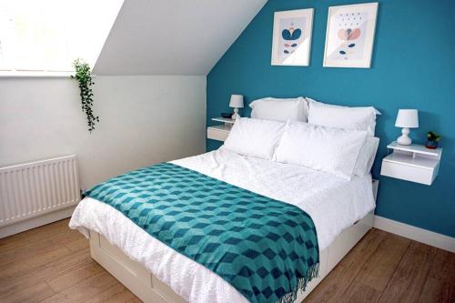 1 dormitorio con 1 cama grande y pared azul en Walking distance to hospital and town with free off-road parking, en Bury Saint Edmunds