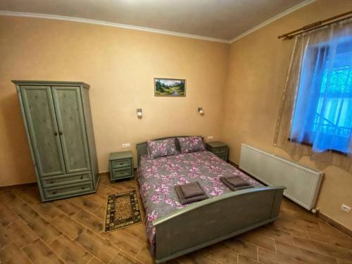 a bedroom with a bed in the corner of a room at Villa Magda in Berehove