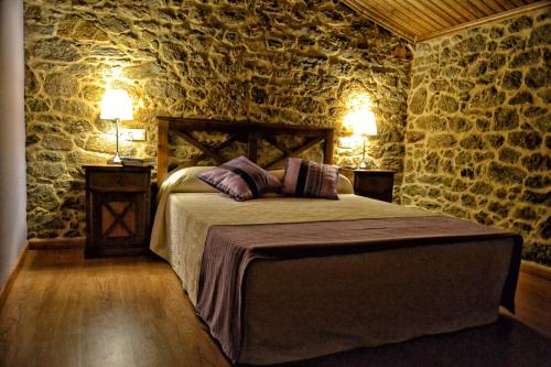a bedroom with a bed with two pillows on it at A Casa do Folgo Turismo Rural in Negreira
