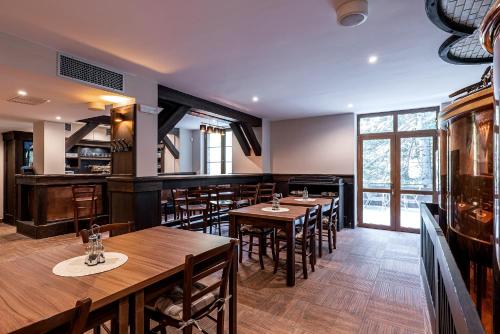 a restaurant with wooden tables and chairs in a room at Wellness Hotel pod Kyčmolem in Horní Lomná