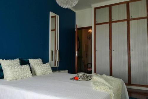 Schlafzimmer mit einem Bett mit blauer Wand in der Unterkunft LightHouse - Rest, Love and Dream in Nazaré