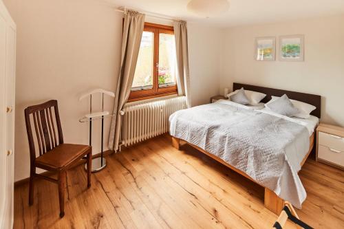 a bedroom with a bed and a window and a chair at Ferienhaus "Am Wäldle" in Feldberg