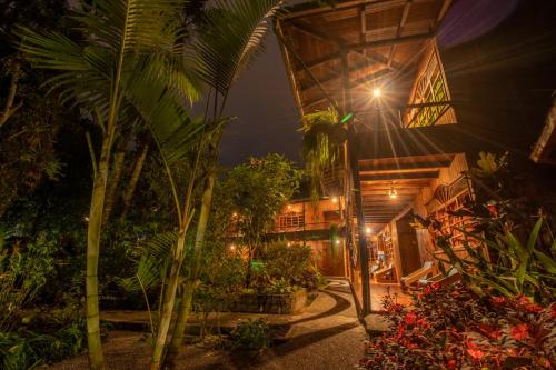 an exterior view of a house with trees and plants at El Jardín Hotel & Restaurante in Puyo