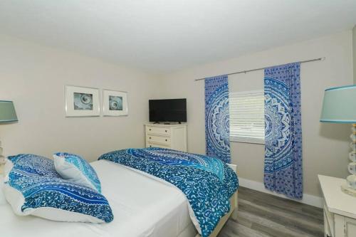 a bedroom with a bed with blue and white sheets at Siesta Key Village-Suite #3: A Block to the Beach! in Sarasota