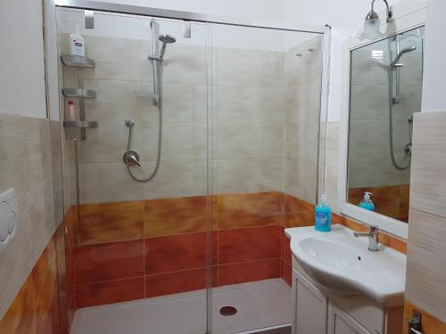 La salle de bains est pourvue d'une douche en verre et d'un lavabo. dans l'établissement BORGO NEL TEMPO, à Collestatte