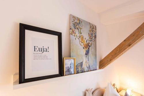 a picture frame on a wall with two pictures at Landhotel Gutshof in Hartenstein