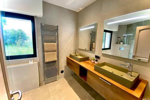 une salle de bain avec deux lavabos verts et un miroir dans l'établissement VILLA CORSA**** PISCINE VUE MER PANORAMIQUE, à Santa-Reparata-di-Balagna