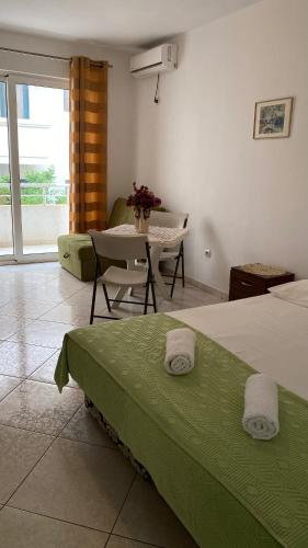 a hotel room with a bed and a table and a table at Villa Alba Apartments in Dobra Voda