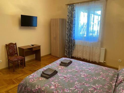 a bedroom with a bed and a desk and a window at Villa Magda in Berehove