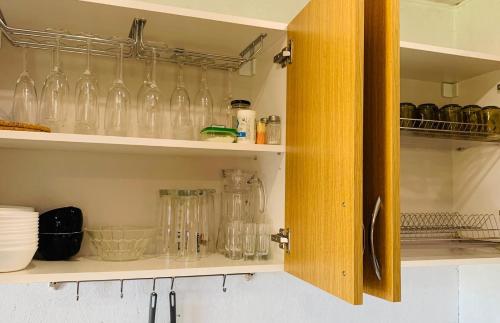 a kitchen cabinet filled with lots of glass bottles at Anykščių raj. Žalioji Stotelė in Šventupys