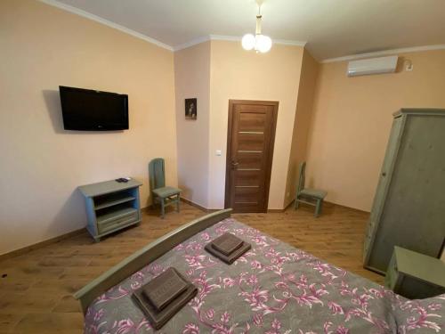 a bedroom with a bed and a flat screen tv at Villa Magda in Berehove