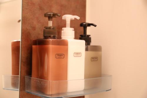 two soap dispensers on a shelf in a bathroom at ケイアイコンホテルズ 新栄8階又は10階 in Nagoya