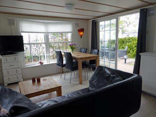 een woonkamer met een bank en een tafel bij Tiny house Appelvinkje, huisje met bedstee in bosrijke omgeving in Oisterwijk