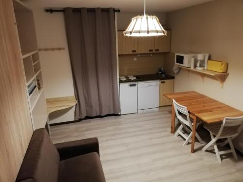 a small kitchen with a wooden table and a dining room at Studio LUPIN Eyne pied de pistes in Eyne