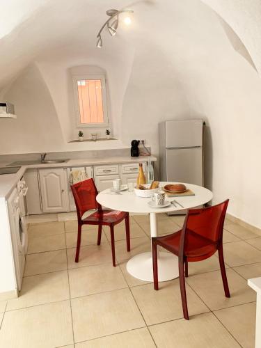 une cuisine avec une table, des chaises et un réfrigérateur dans l'établissement CASA A CERTOSA au cœur de la Citadelle, à Bastia