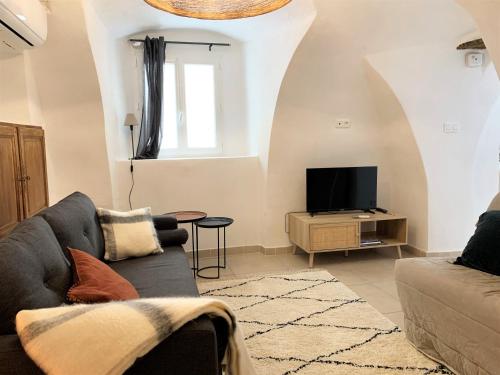 a living room with a couch and a tv at CASA A CERTOSA au cœur de la Citadelle in Bastia
