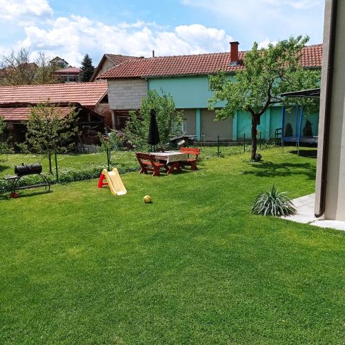 a yard with a playground with a table and a ping at Guest house Dagovic in Bajina Bašta