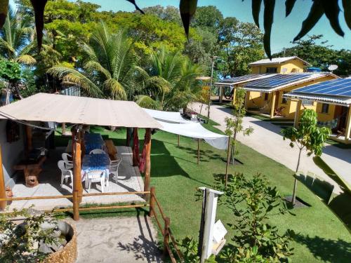 - une vue sur une maison avec un parasol et une cour dans l'établissement Vila Guaiamum, à Cumuruxatiba