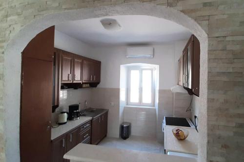 a kitchen with wooden cabinets and an archway at Old Town Heart in Kotor