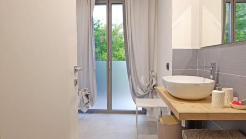 baño con lavabo y ventana grande en In Collina B&B en Trento