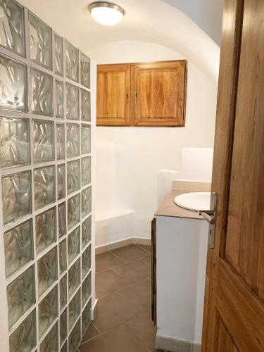 une cuisine avec un mur en carreaux de verre dans l'établissement CASA A CERTOSA au cœur de la Citadelle, à Bastia