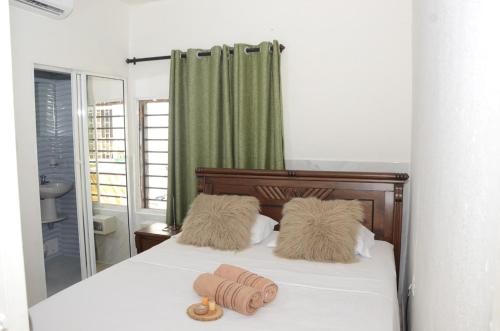 ein Schlafzimmer mit einem Bett mit zwei Kissen darauf in der Unterkunft Hostal Marbella 47 in Cartagena de Indias