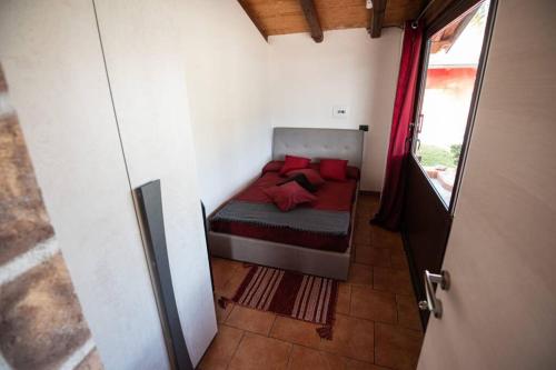 una piccola camera da letto con letto con cuscini rossi di Villa Sole a Torrenova