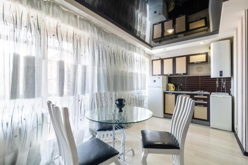 eine Küche und ein Esszimmer mit einem Glastisch und Stühlen in der Unterkunft New apartment Lux in Most City area in Dnipro