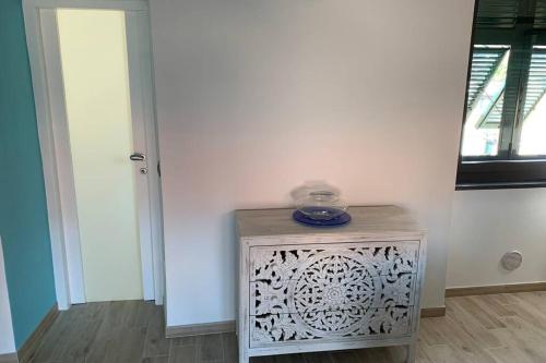 Cette chambre est dotée d'un mur blanc et d'une table avec un téléphone. dans l'établissement Appartamento Sentiero Azzurro 2, à La Spezia