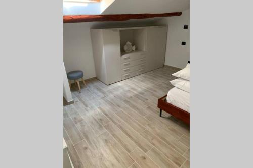 een slaapkamer met een bed en een houten vloer bij Appartamento Sentiero Azzurro 2 in La Spezia