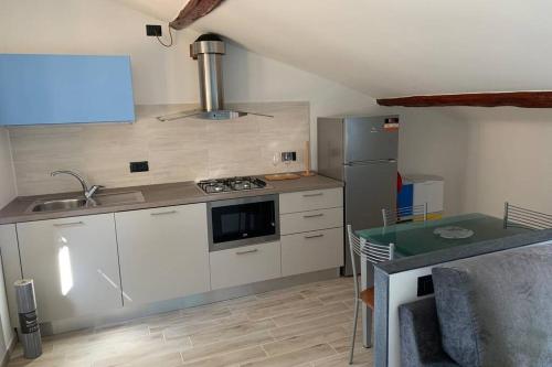 una pequeña cocina con fregadero y nevera. en Appartamento Sentiero Azzurro 2, en La Spezia