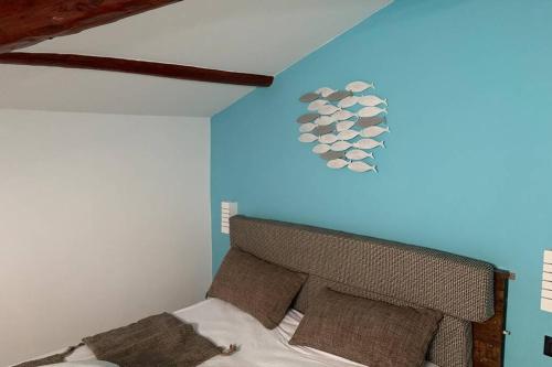 1 dormitorio con 1 cama con pared azul en Appartamento Sentiero Azzurro 2, en La Spezia