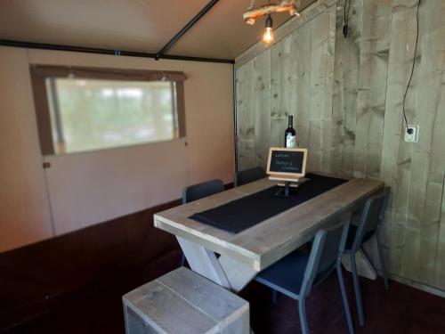 a room with a table with a laptop on it at Safaritent Kvikkjokk Vledder, locatie Kraanvogels 3 in Vledder