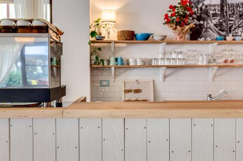 a kitchen with white cabinets and a counter top at Piccolo Hotel Kursaal in Cesenatico