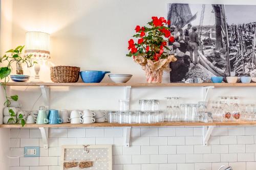 a kitchen with shelves with flowers on them at Piccolo Hotel Kursaal in Cesenatico