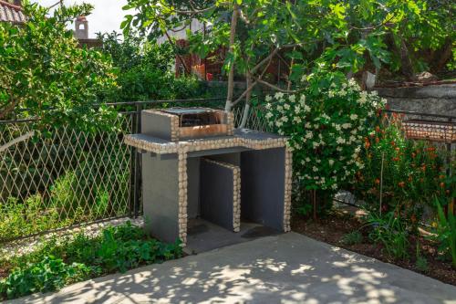 a stone oven sitting in the middle of a garden at Rooms Molabeciri in Ulcinj