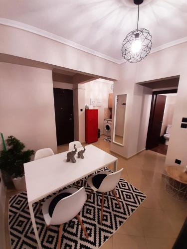 a living room with a white table and chairs at Sweet Apartment in Thessaloniki