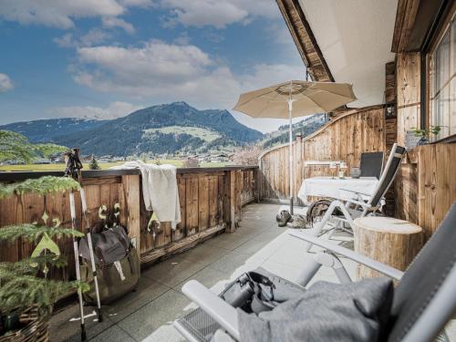 a balcony with a table and an umbrella at Aparthotel Stacherhof in Fügen