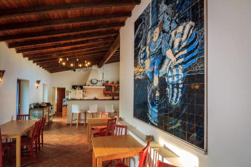 a dining room with tables and a large painting on the wall at The New Laziness in São Luis