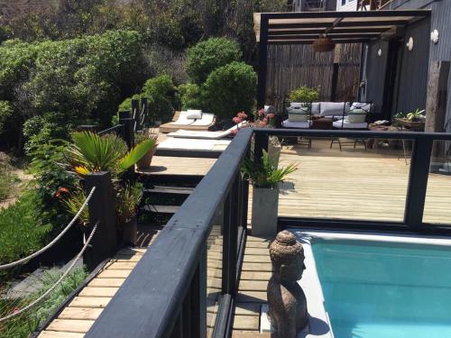 a backyard with a swimming pool and a wooden deck at B&B Casa Las Brisas Matanzas in Matanzas