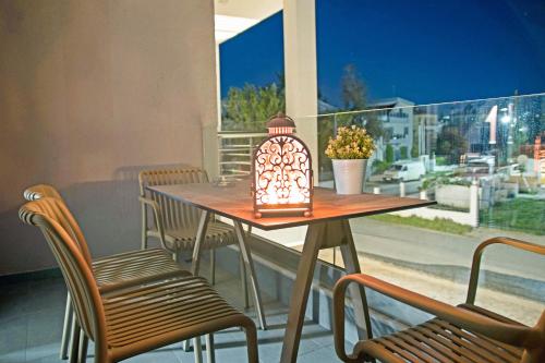 een tafel met een lantaarn op een balkon met stoelen bij Aelia Luxury Apartments in Nikiti