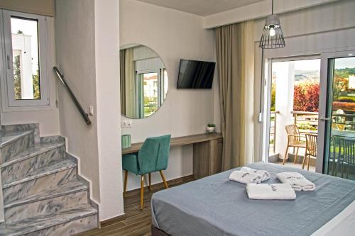 een hotelkamer met een bed en een spiegel bij Aelia Luxury Apartments in Nikiti